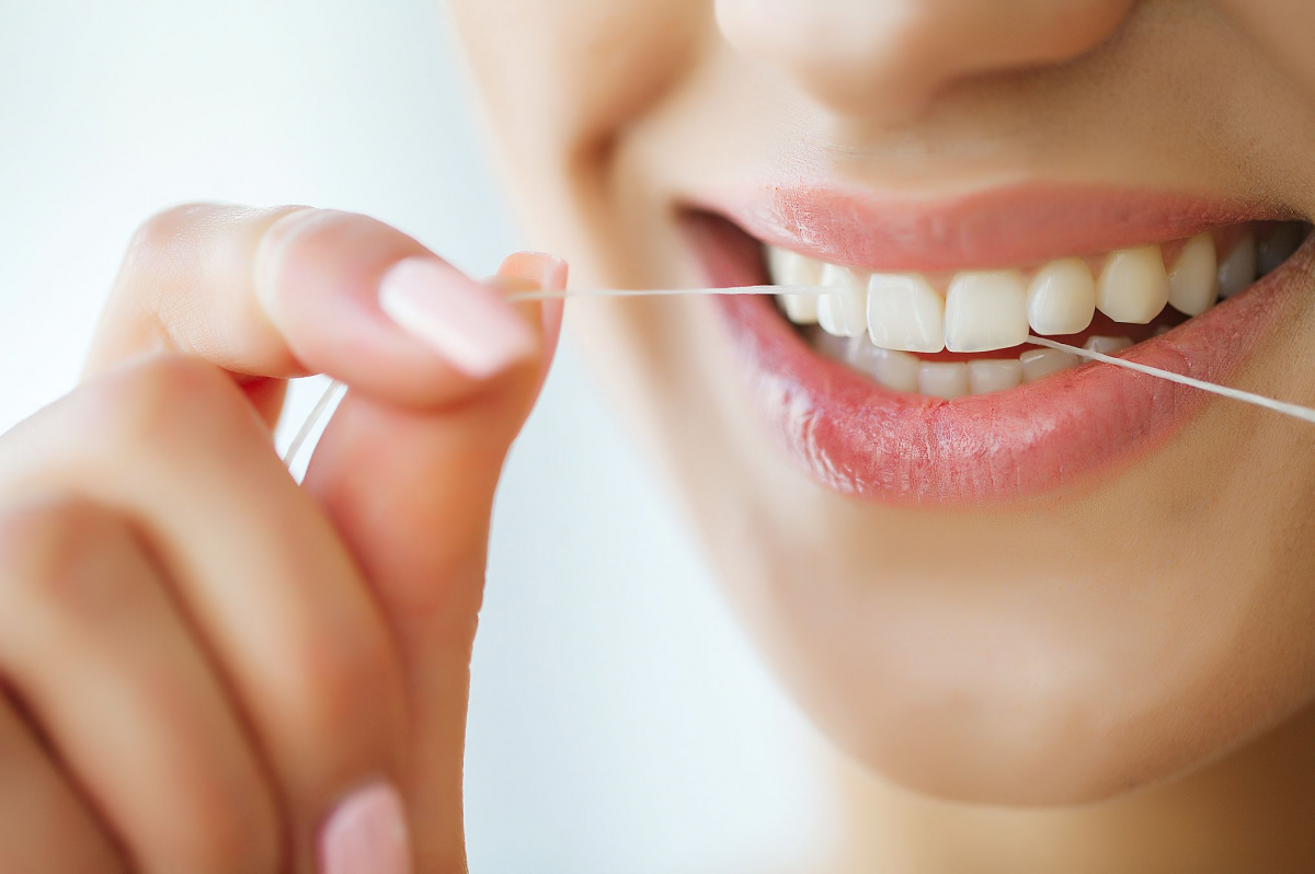 Seorang wanita sedang lakukan flossing 